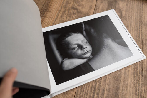 A photo of a baby lying on a book

Description automatically generated with low confidence